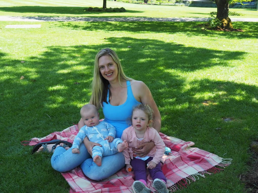 Natasha on a picnic blanket with her two young children