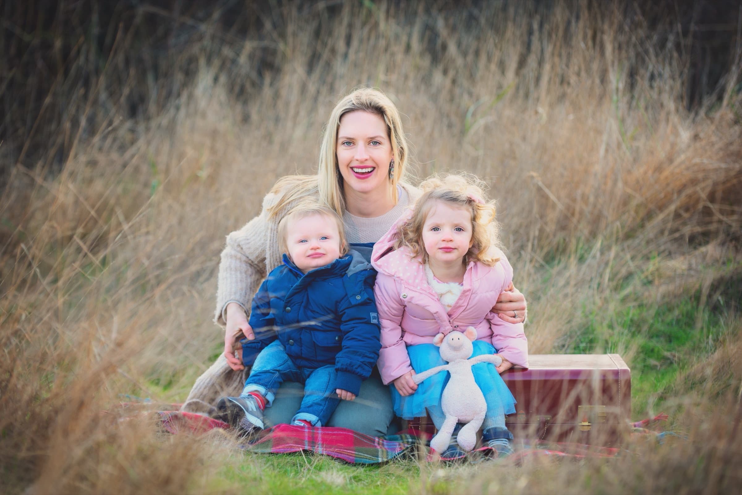 Natasha with her two children in tall grass