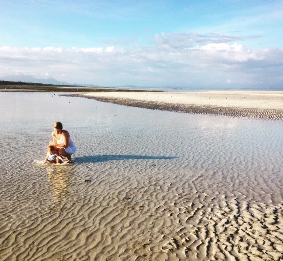 A child playing on wide tidal flats at the beach